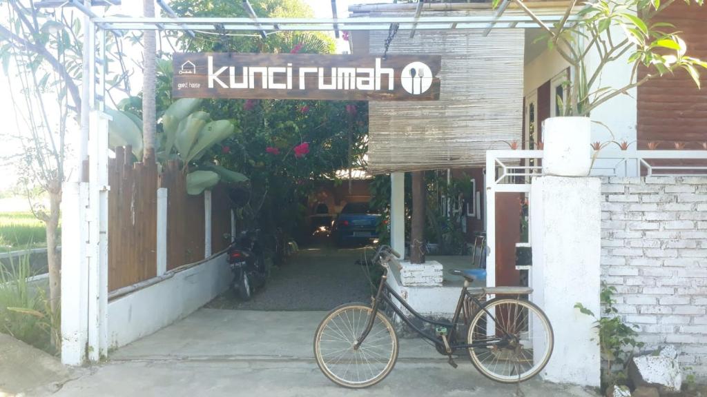 a bike parked outside of a building with a sign at kunci rumah in Sorongjukung