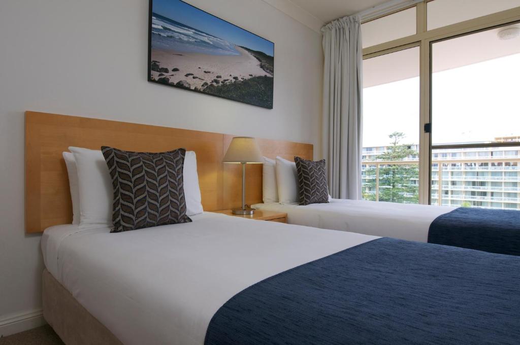 a hotel room with two beds and a window at Club Wyndham Port Macquarie in Port Macquarie