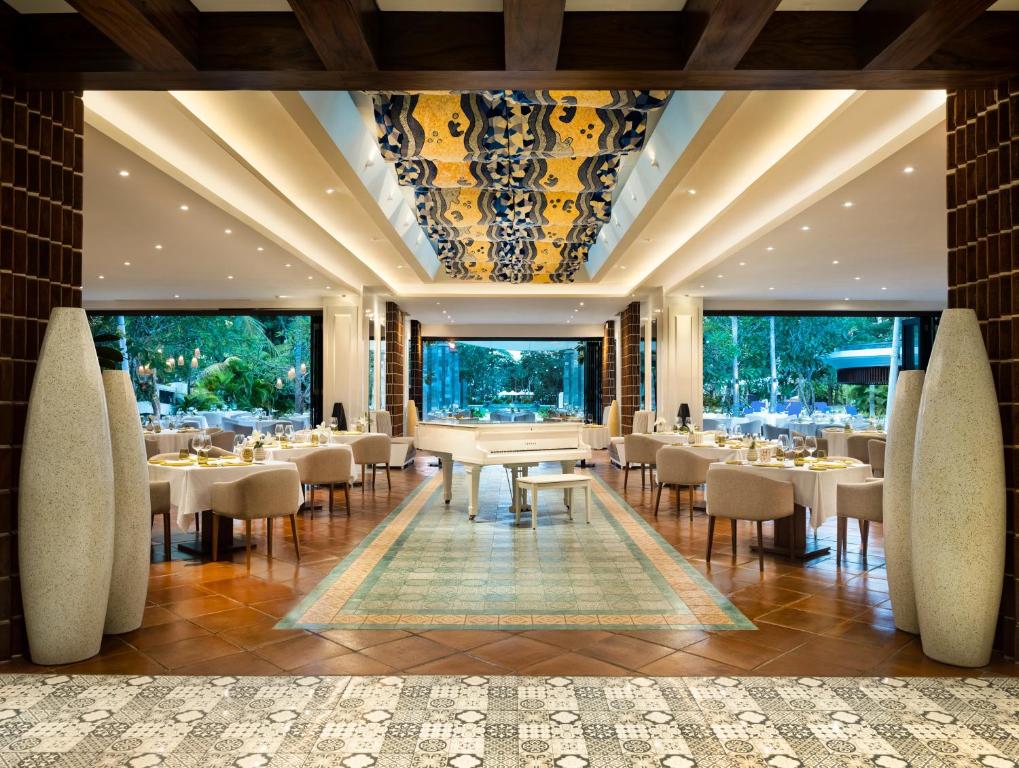 a restaurant with tables and chairs and large windows at Sofitel Bali Nusa Dua Beach Resort in Nusa Dua