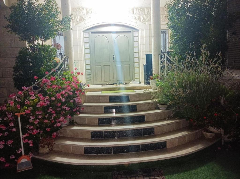 uma porta da frente de uma casa com escadas com flores em Jerusalem Villa em Jerusalém
