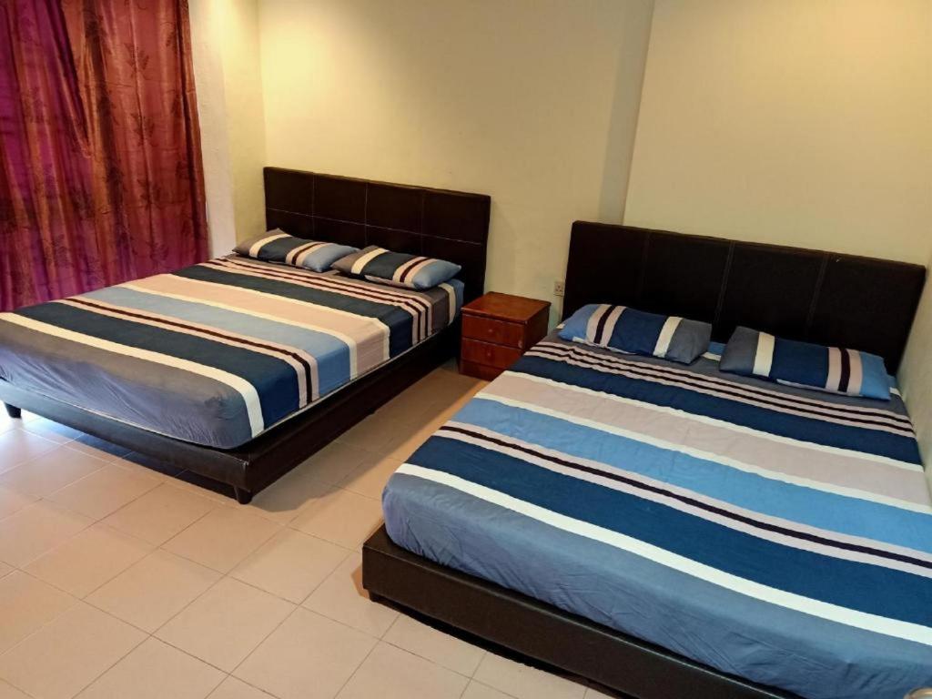 two beds in a room with two beds sidx sidx sidx at OYO 90842 Hotel Prai Jaya in Perai