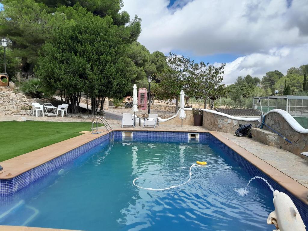 una piscina con un tobogán de agua en un patio en Casa de montaña en plena naturaleza, jacuzzi, sauna y piscina, en Bisbal del Penedès