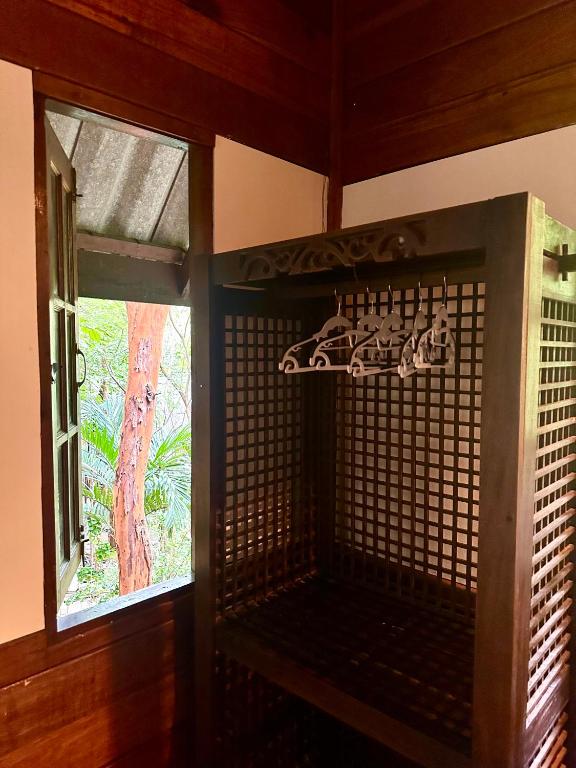 a room with a window and a rack with shoes at Bambu Huts in Baan Tai