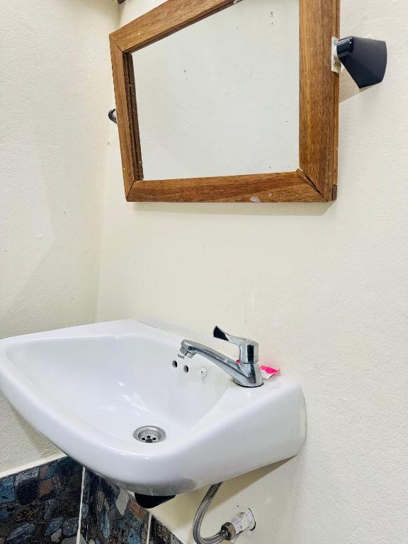 a white sink in a bathroom with a mirror at Bambu Huts in Baan Tai
