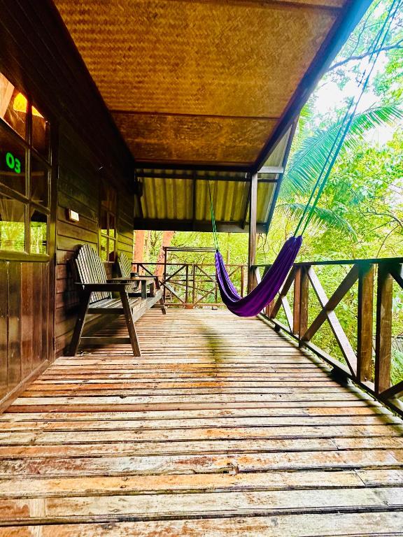 a hammock on the deck of a cabin at Bambu Huts in Baan Tai