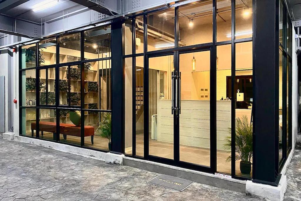 a store front with glass doors with a bench in it at 44 Room Rama 3 in Bangkok