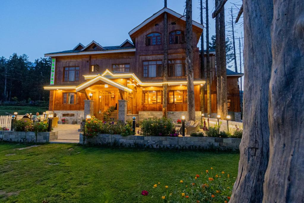 a large wooden house with lights in front of it at Shaw Inn by Stay Pattern in Gulmarg