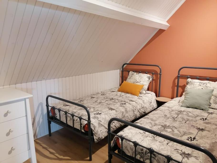Curtil-VergyにあるGîte Hautes Côtes de Nuitsのオレンジ色の壁の客室内のベッド2台