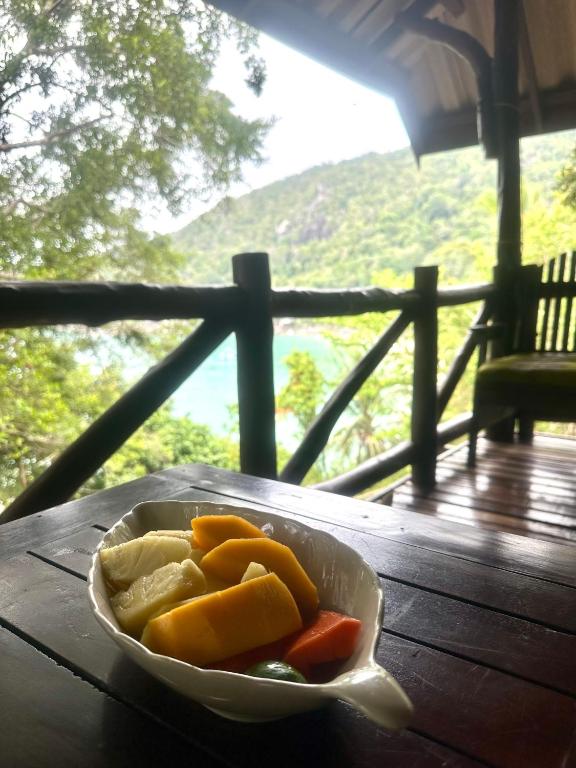 a bowl of vegetables sitting on a wooden table at Bambu Huts in Baan Tai