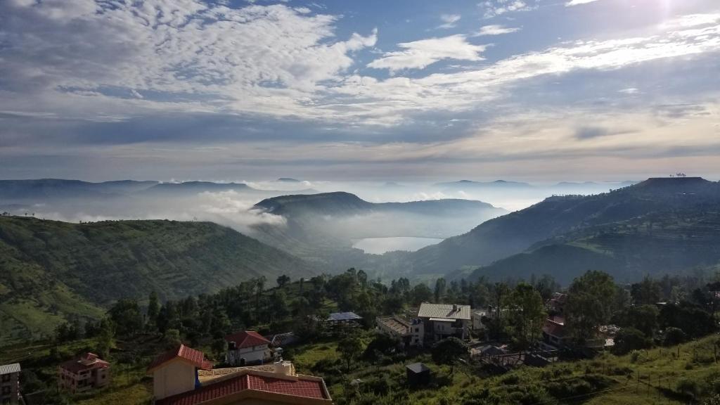 a view of a valley in the mountains with clouds at Tabletop Villa Jacuzzi Suite - valley view in Panchgani