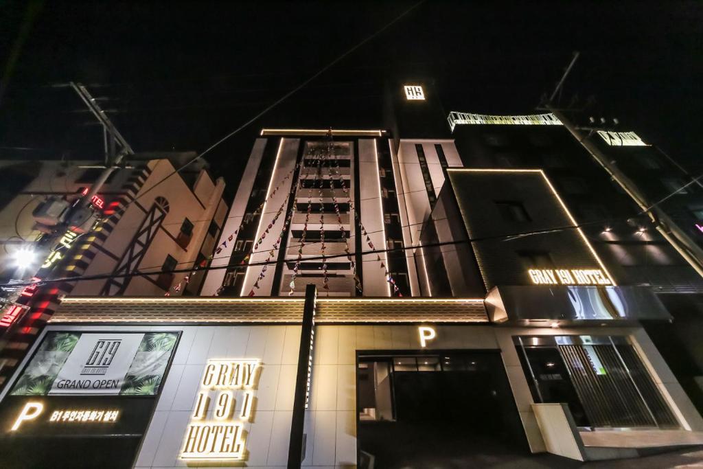 un edificio alto con un cartel en él por la noche en Gray 191 Hotel en Busan