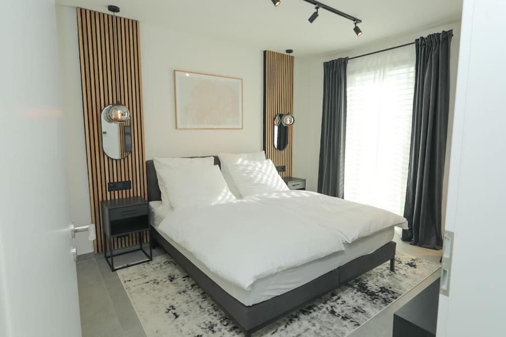 Un dormitorio con una cama blanca y una ventana. en TimeTidy III, en Hochheim am Main