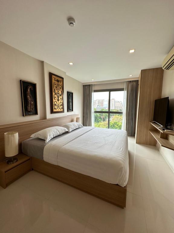 a bedroom with a large bed and a television at City Garden Tropicana Condo Naklua in Pattaya North