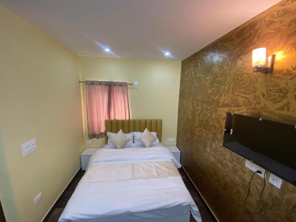 een slaapkamer met 2 bedden en een flatscreen-tv bij Skylight homestay in Dehradun