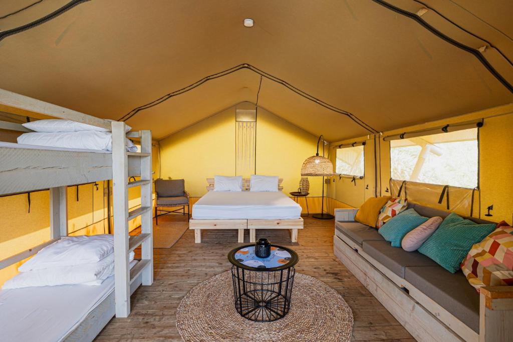 a room with two bunk beds and a couch at Layla Glamping in Nir Dawid