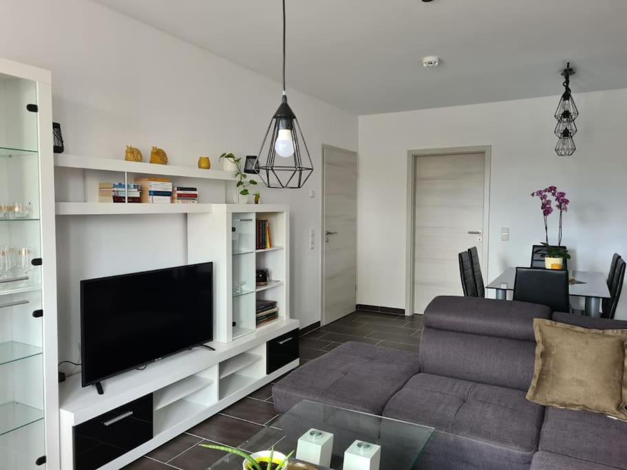 a living room with a couch and a flat screen tv at Gästewohnung KL. WZL 38_3 in Klein Wanzleben