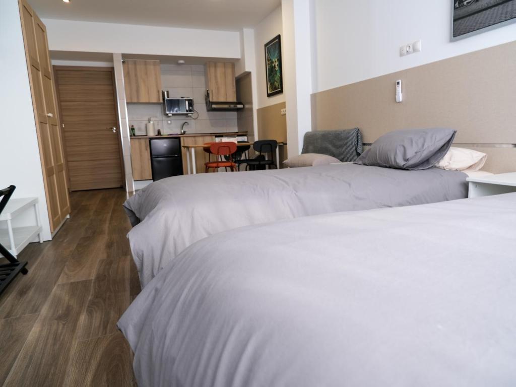 Habitación de hotel con 2 camas y cocina en Alianza Suites, en Madrid