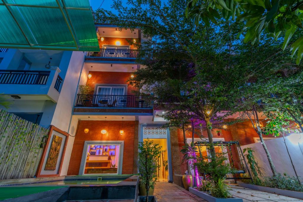 a house with a tree in front of it at Angkor Rithy Boutique Group in Siem Reap