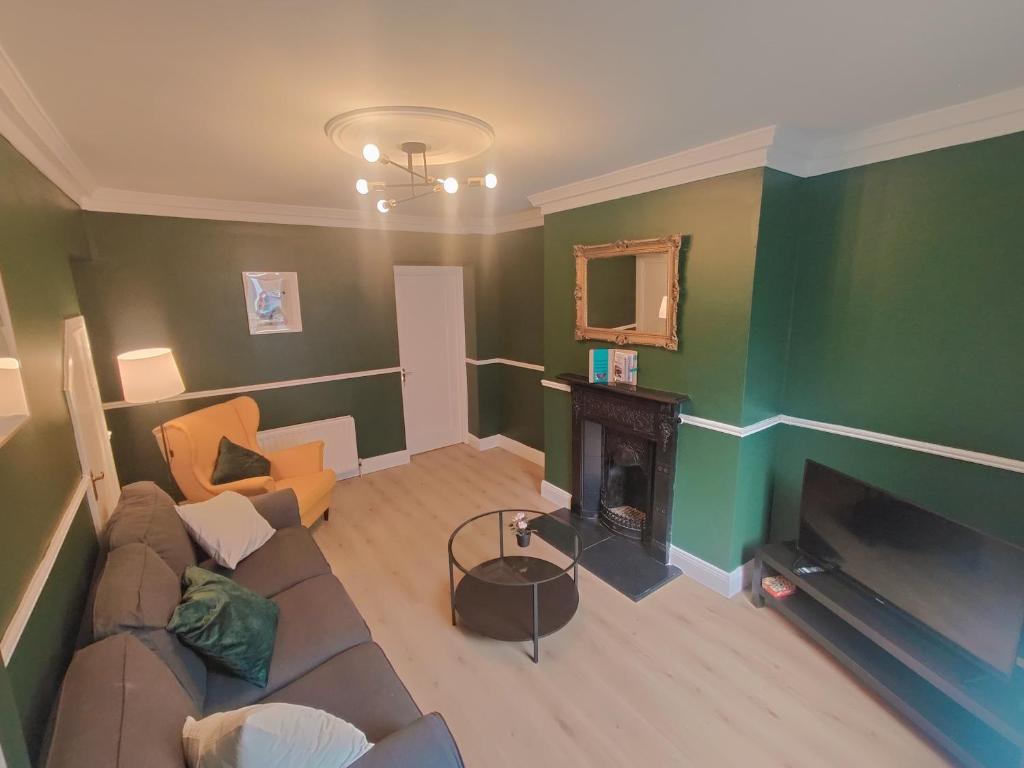 a living room with a couch and a fireplace at Modern 4 Bedroom Townhouse in City Centre in Dublin