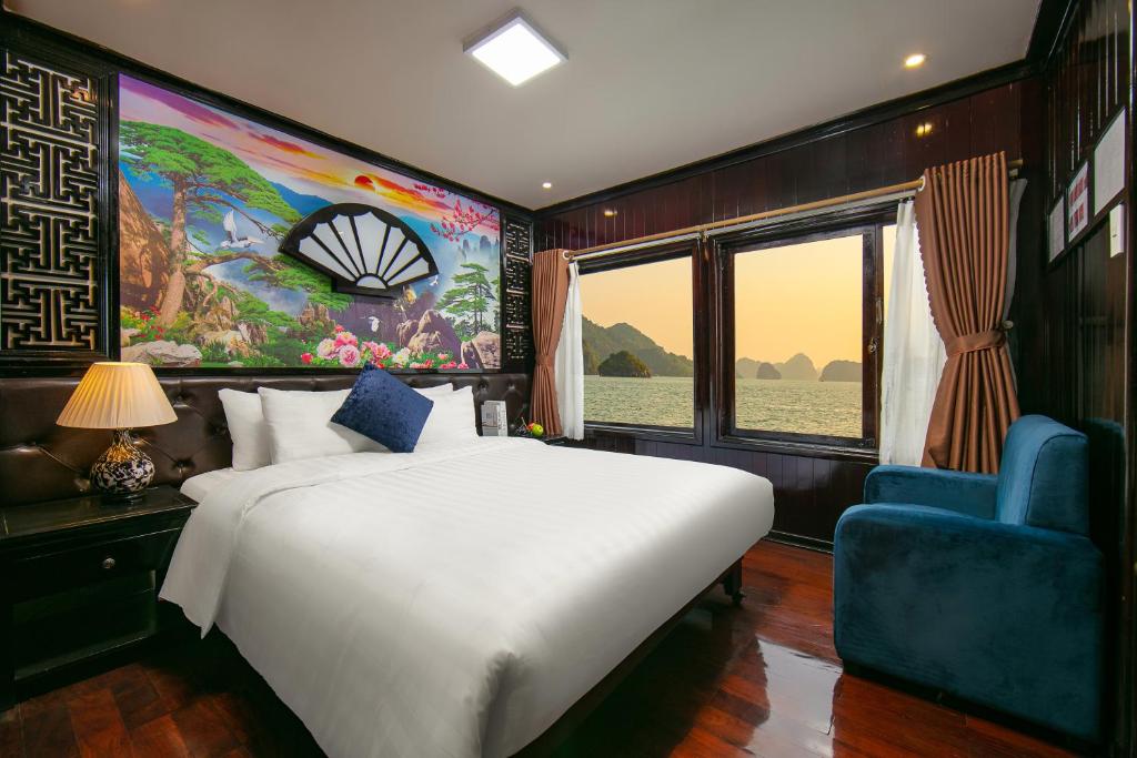 ein Schlafzimmer mit einem großen weißen Bett und einem blauen Stuhl in der Unterkunft Halong Fantasea Cruise in Hạ Long