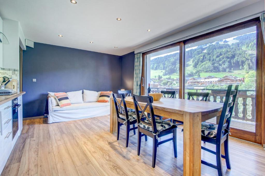 une cuisine et une salle à manger avec une table et des chaises dans l'établissement Sabaudia Appartement deux chambres plein sud et à proximité du centre du village, à Morzine