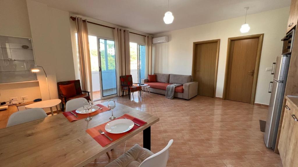 - un salon avec une table, des chaises et un canapé dans l'établissement Marina Apartment, à Durrës