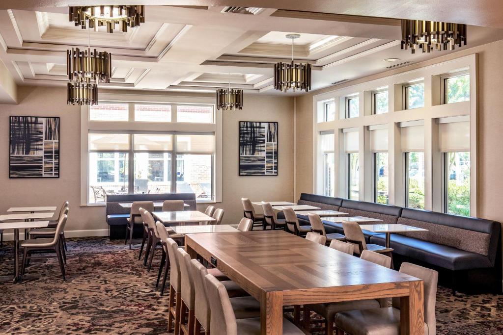 a dining room with tables and chairs and windows at Residence Inn by Marriott Chesapeake Greenbrier in Chesapeake