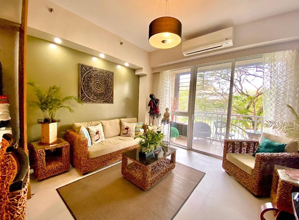 a living room filled with furniture and a large window at Pico De Loro 2BR Carola B Unit with Lagoon View in Nasugbu