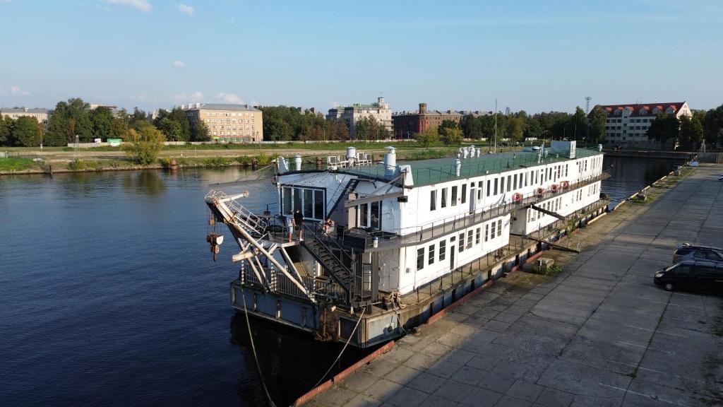 Un grand bateau est amarré sur une rivière. dans l'établissement Float House Nr 659, à Riga