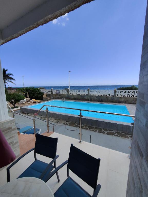 a view of a swimming pool with two chairs at Los Nidos in San Bartolomé