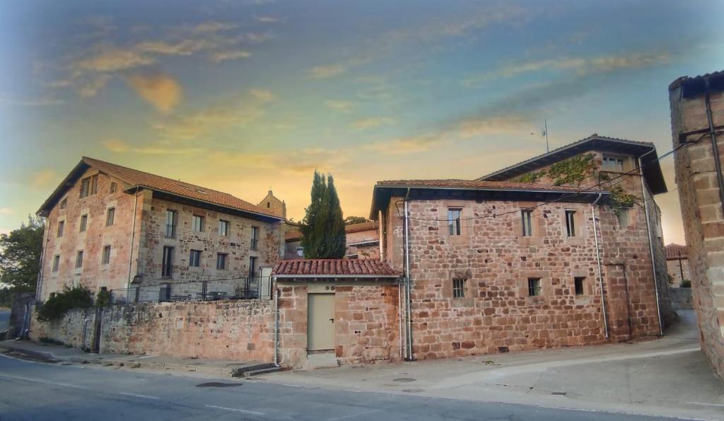 un viejo edificio de ladrillo al lado de una calle en Maison Barón de la Galleta B&B en Quintanilla de las Torres