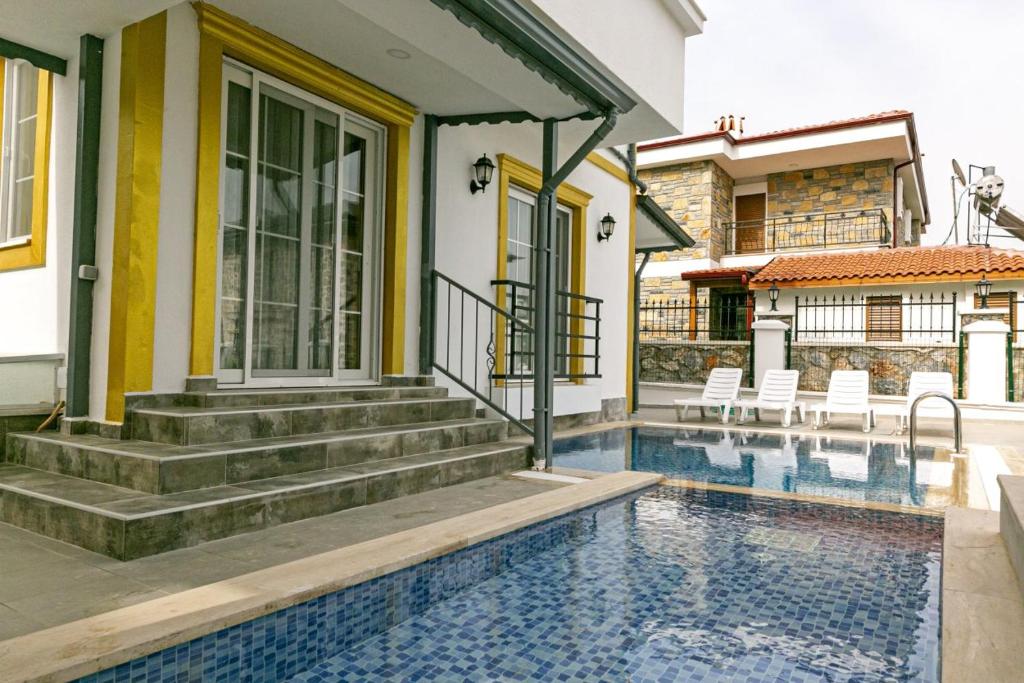 uma casa com piscina e escadas ao lado de uma casa em Turkuaz Villa em Muğla