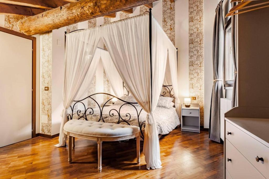 una camera con letto a baldacchino e panca di Design Villa with parking Navigli area Milan a Milano