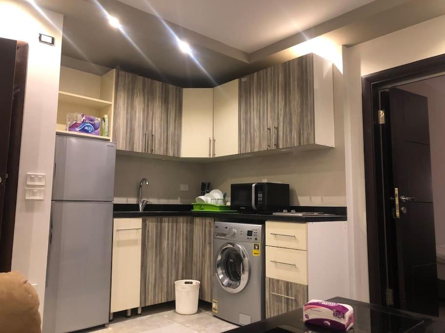 a kitchen with a washer and a sink and a refrigerator at Lovely studio in the heart of heliopolis, cairo in Cairo