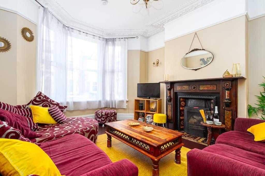 uma sala de estar com mobiliário vermelho e uma lareira em Beautiful Townhouse, great location - Pet Friendly em Cardiff