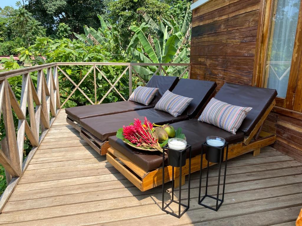 a couch on a deck with a bowl of flowers on it at Valdivia Homes -Príncipe in Santo António