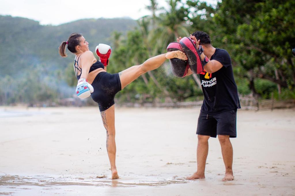 Zwei Männer und eine Frau stehen am Strand in der Unterkunft Fight Club Philippines Fitness Resort in Bacungan