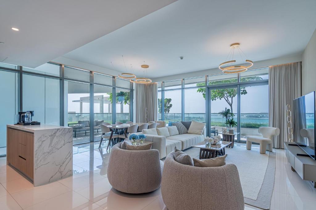 uma sala de estar com um sofá, cadeiras e janelas em CitiHome-3BR Marina with beach view no Dubai