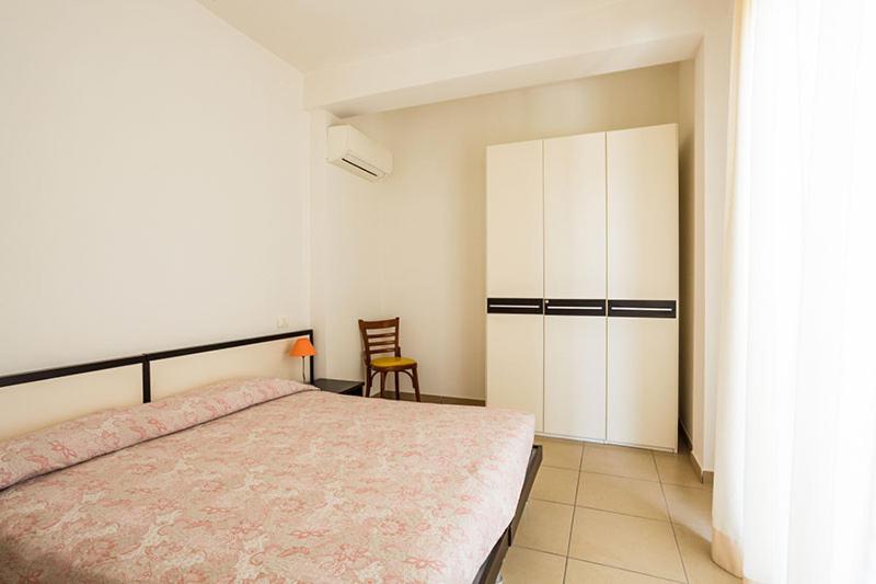 um quarto com uma cama e um armário branco em Residence Roxy em Misano Adriatico