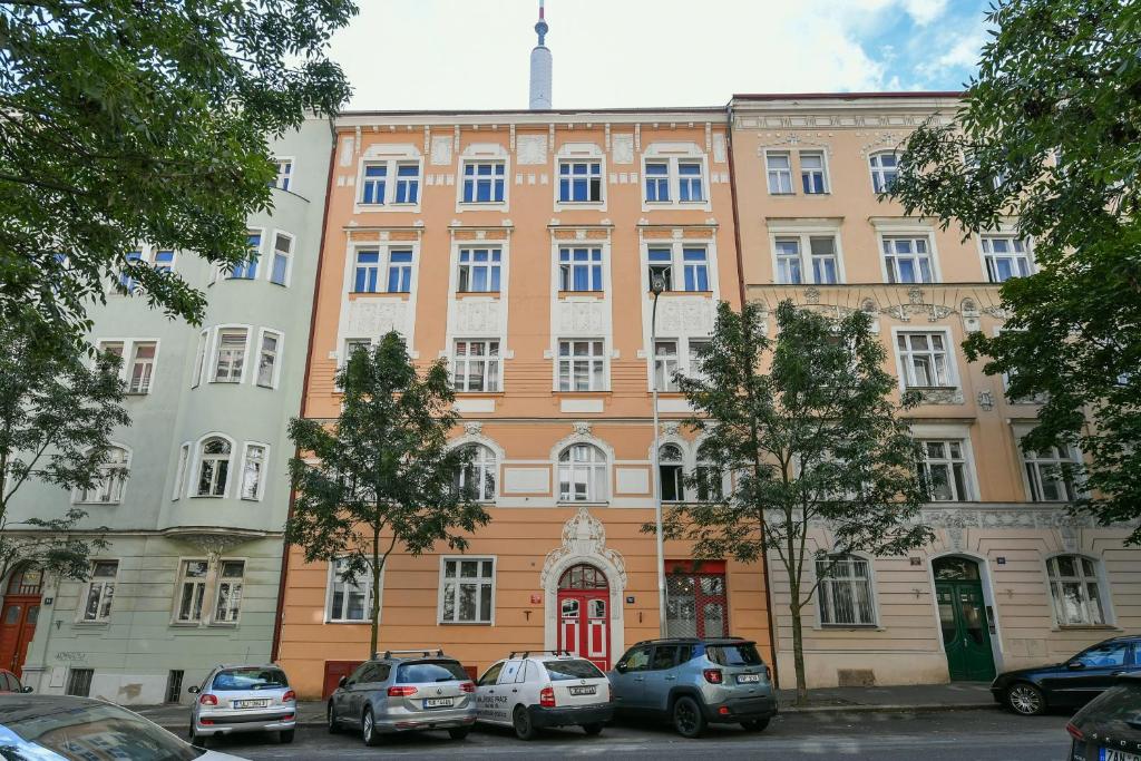 un grand bâtiment avec des voitures garées devant lui dans l'établissement Kubelíkova 32 Residence, à Prague