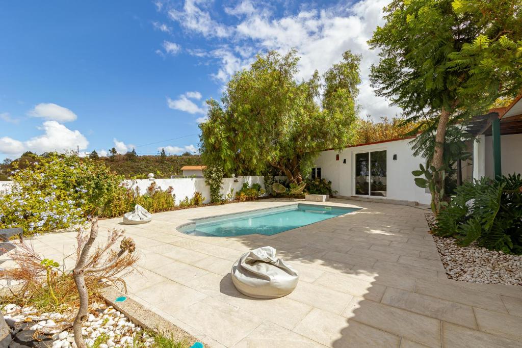 une arrière-cour avec une piscine et une maison dans l'établissement Lunatika house, à Vega de San Mateo