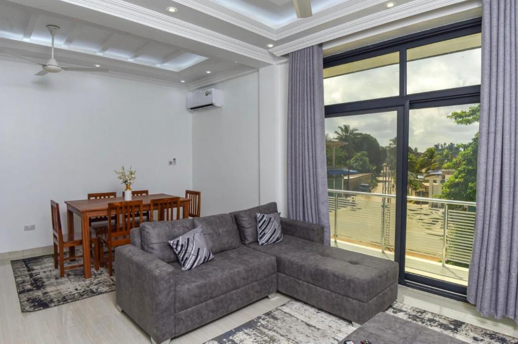 a living room with a couch and a table at JOY B Apartment 2 in Kiembi Samaki