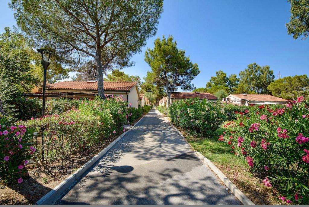 a walkway in a garden with flowers at ISA-Appartament plus 4 beds, air conditioning and private outdoor area in Village with 6 swimming-pools in Piombino