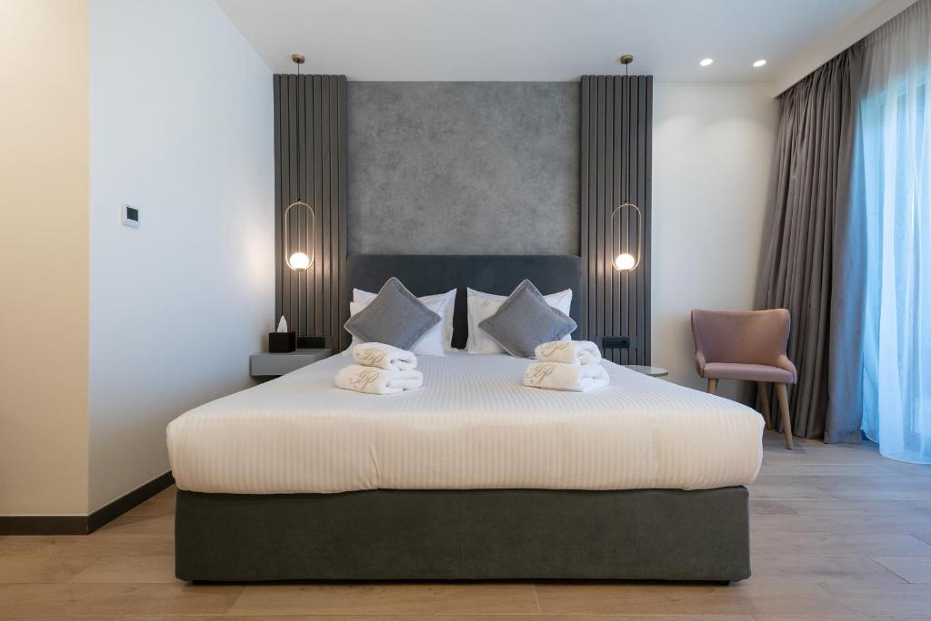 a bedroom with a large bed with towels on it at GRAND PATELLI in Myrina