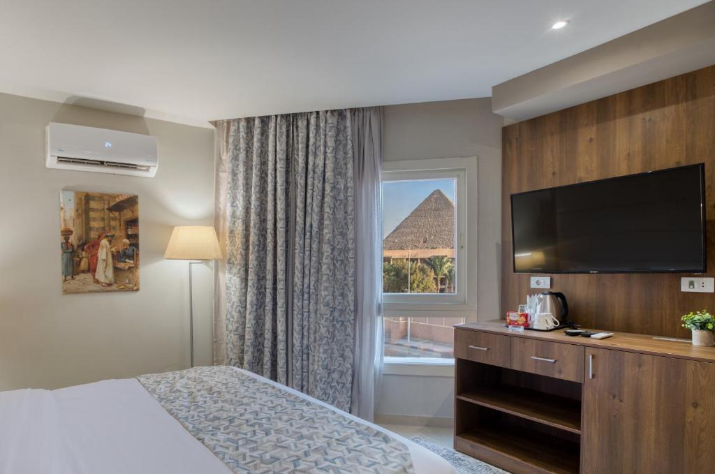 Postel nebo postele na pokoji v ubytování Nozol Pyramids Hotel and Spa