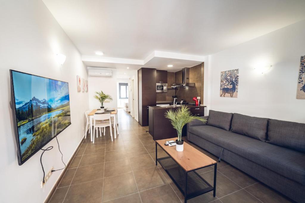 VISTALEGRE Apartments في مدريد: غرفة معيشة مع أريكة وطاولة