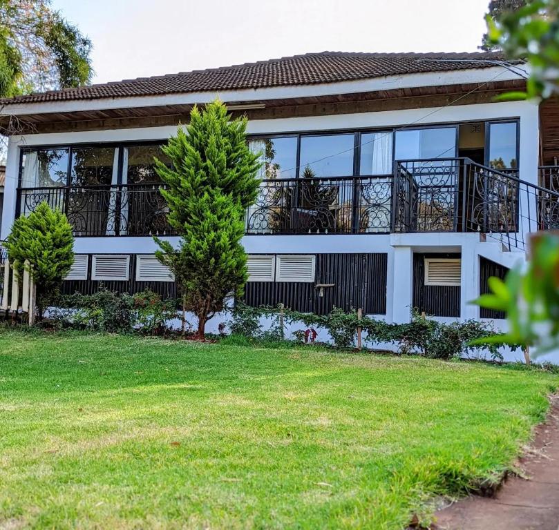 ein Haus mit einem großen Fenster und einem Hof in der Unterkunft Thayu Farm Hotel in Limuru