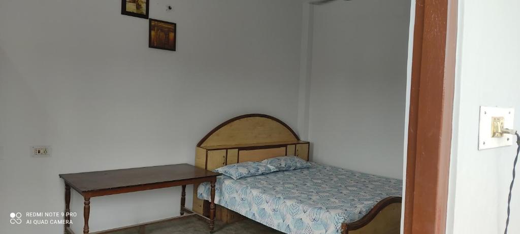 a small bedroom with a bed and a table at Double Bedroom in Homestay in Gorakhpur
