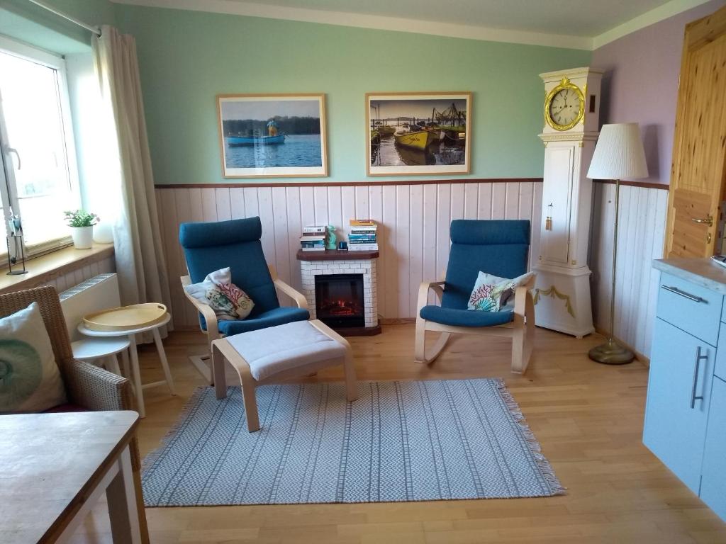 uma sala de estar com duas cadeiras e uma lareira em Lütt Logis in Grödersby em Grödersby