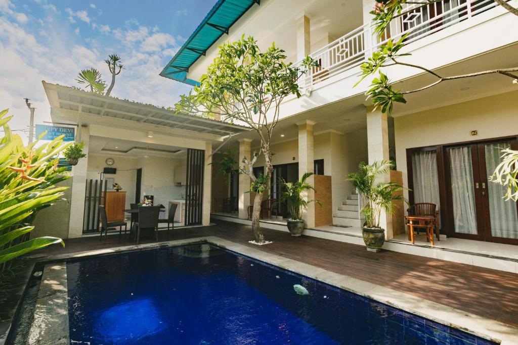 une villa avec une piscine en face d'une maison dans l'établissement Happy Devi Guesthouse, à Canggu